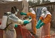 Vorschau Ein Mitarbeiter des Roten Kreu­zes desinfiziert in Conakry die Handschuhe eines Kollegen mit einer Chlorlösung. Zwischen 2014 und 2016 gehörte Guinea zu den Ländern, die am stärksten vom Ebola-Ausbruch betroffen waren. Foto: UN Photo/Martine Perret