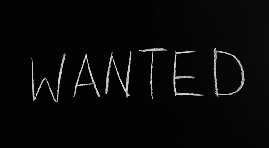 ‘wanted’ written in white chalk on a black board