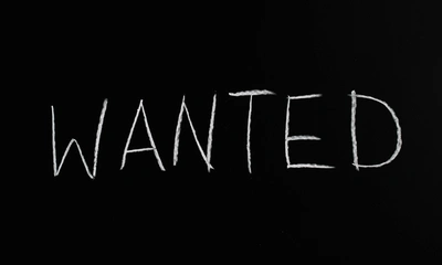 ‘wanted’ written in white chalk on a black board