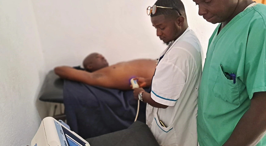 Der Radiologie­Techniker Bernard Zoumanigui führt  bei einem Patienten eine  Fibroscanmessung durch. Foto: Cornelia Staehelin