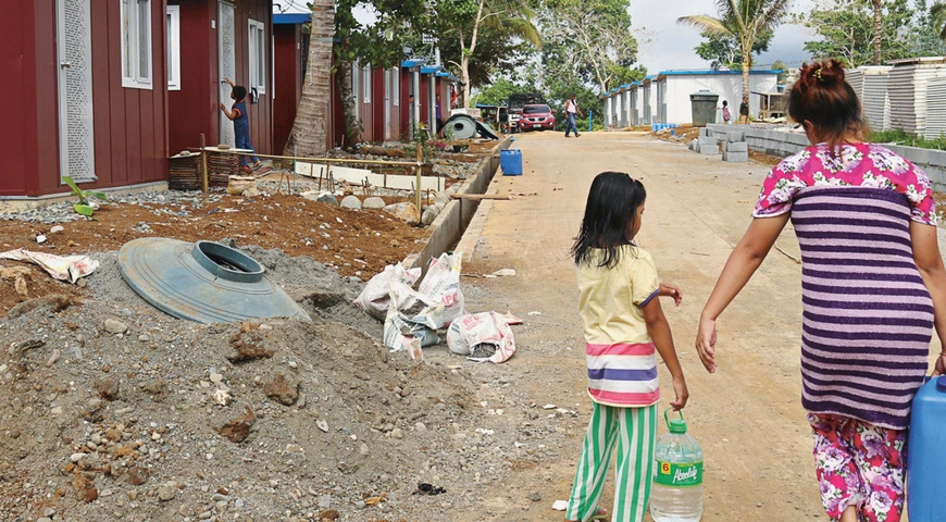Woman and girl carrying water in the Philippines